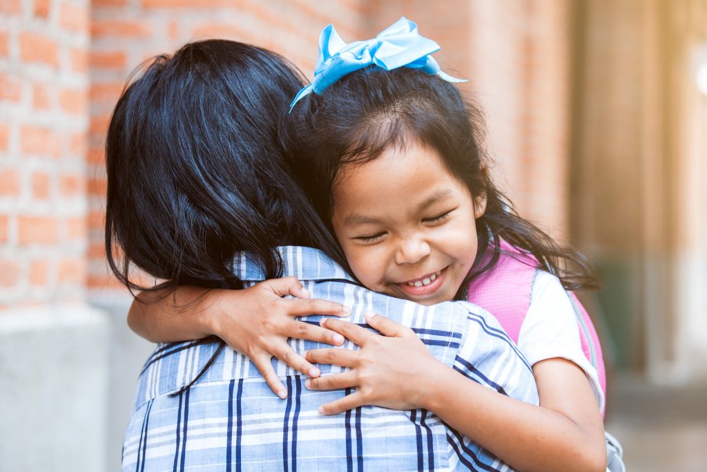 young Hispanic girl hugging her mom