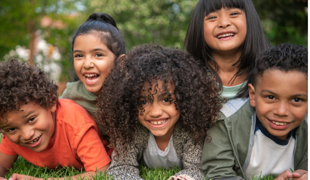 group of young children hanging out together smiling at the camera